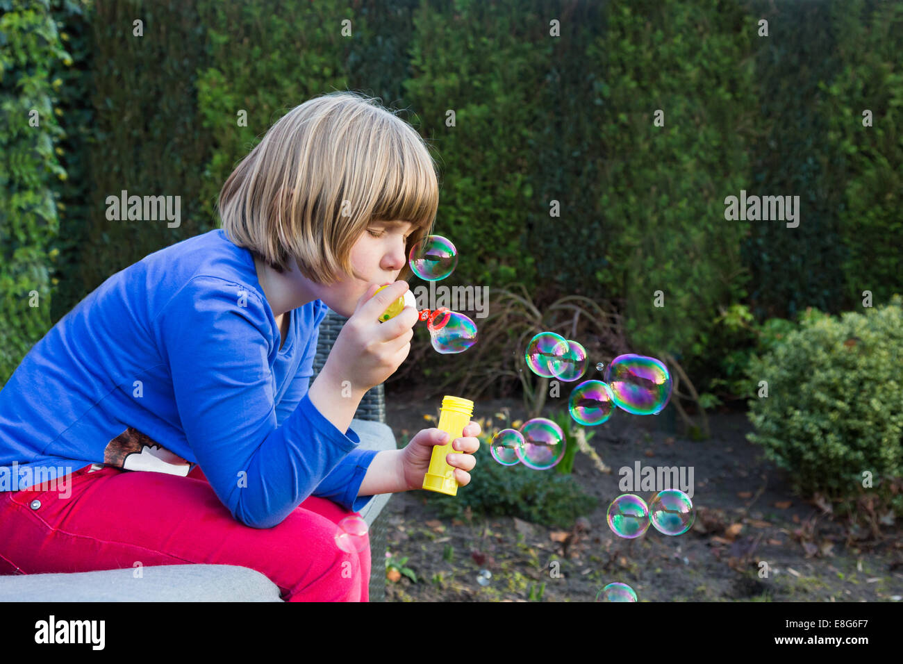 Young girl blowing bubbles from soapy water Stock Photo