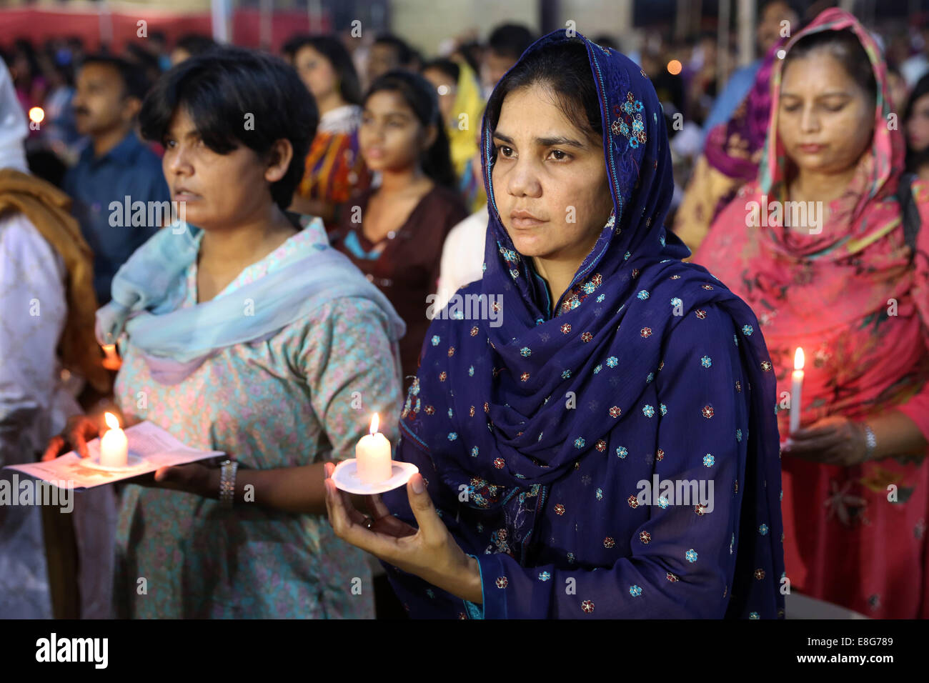 Christian women praying with candles, holy mass service at roman