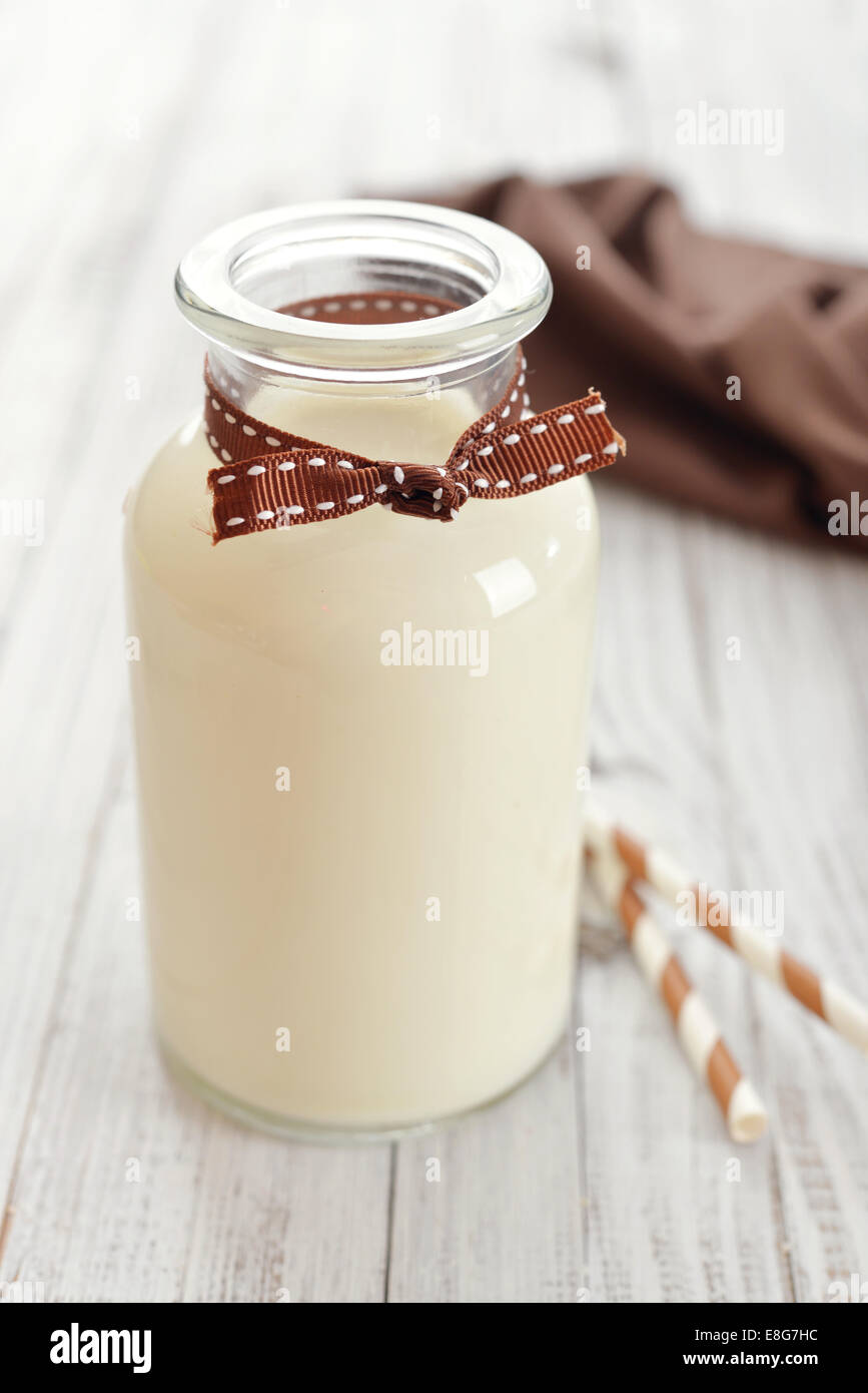 Bottle of milk with straws on wooden background Stock Photo