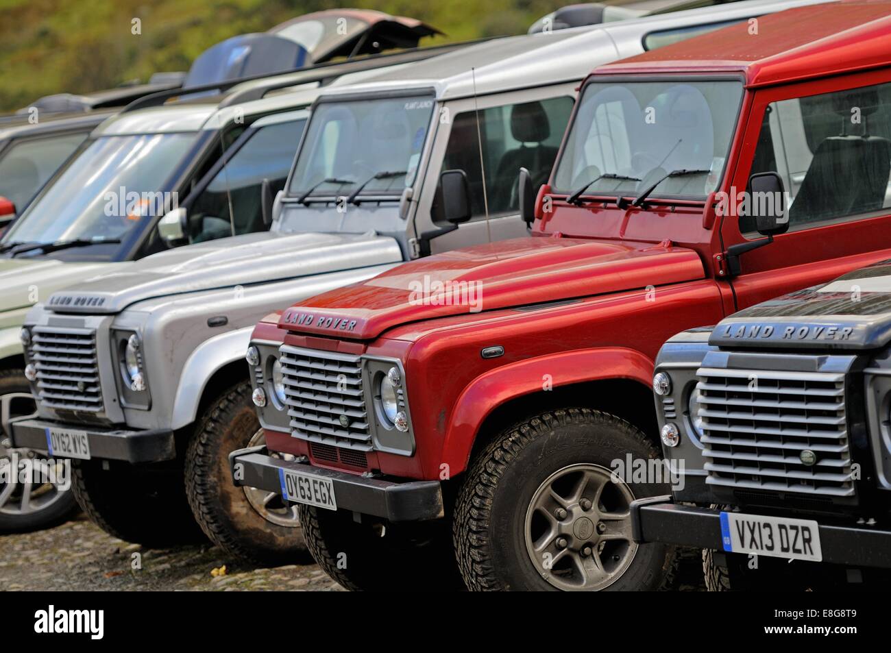Land Rover Defenders standing in a line on moorland in the Lake District Stock Photo