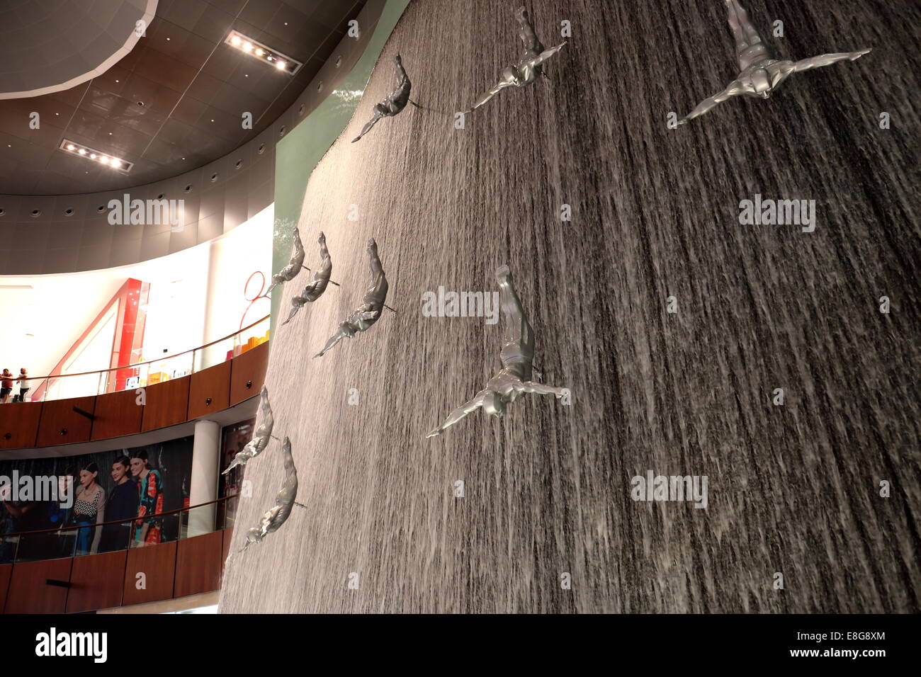 Shops, shoppers, department stores and waterfall with statues of divers