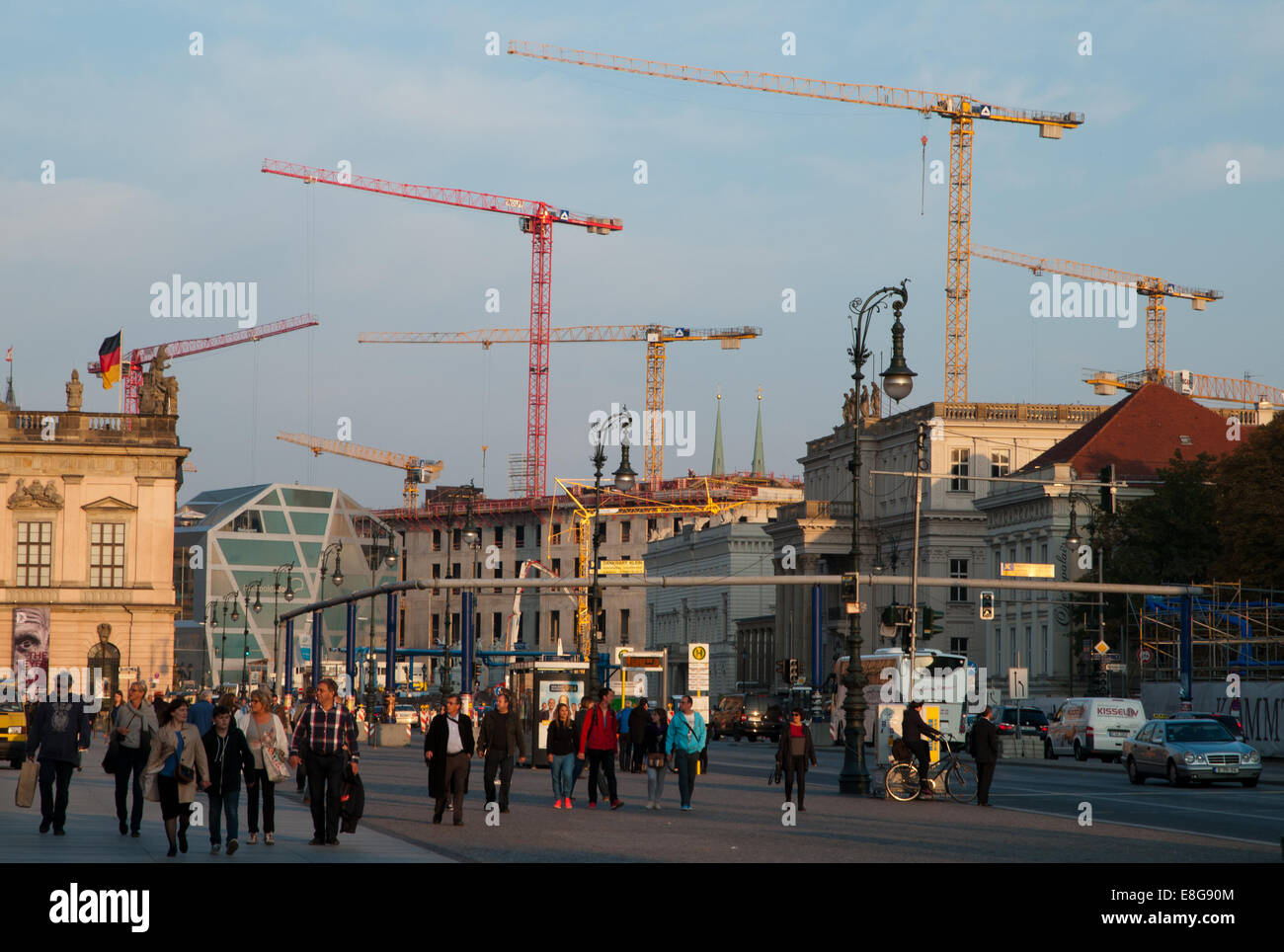 Crowds of tourists on Berlin Unter den Linden boulevard, forest of cranes in central Berlin Stock Photo