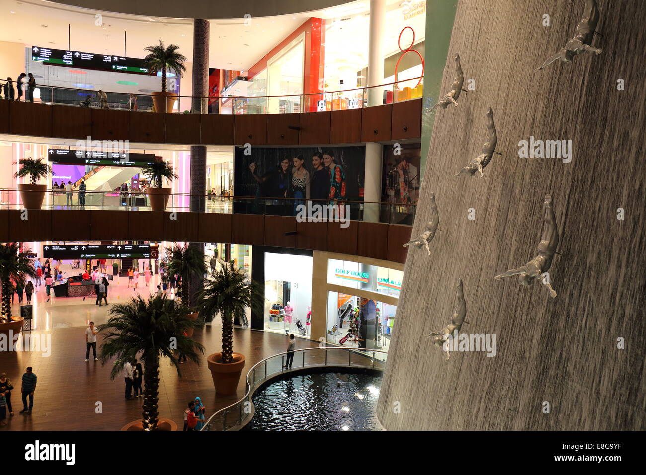Shops, shoppers, department stores and waterfall with statues of divers