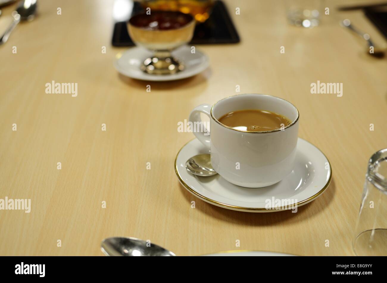 Cup of tea on a Formica covered table with cutlery and a dish of tomato ketchup in the background Stock Photo