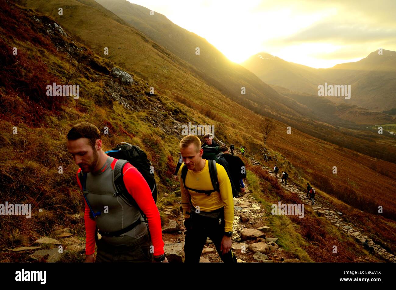 Officers in a hiking party from the Royal Navy trekking up Ben Nevis in the early morning Stock Photo