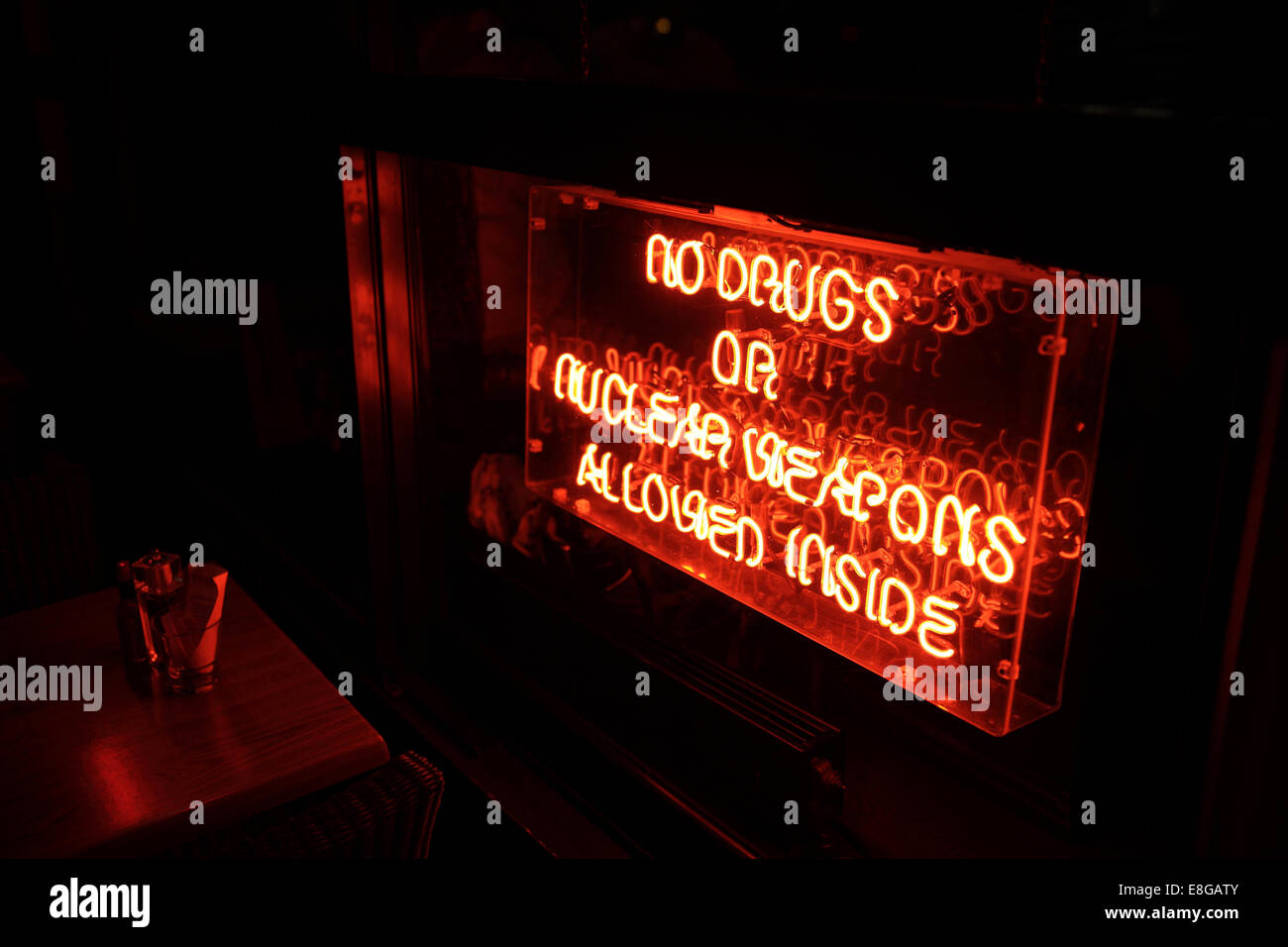 Neon sign prohibiting drugs and nuclear weapons inside building Stock