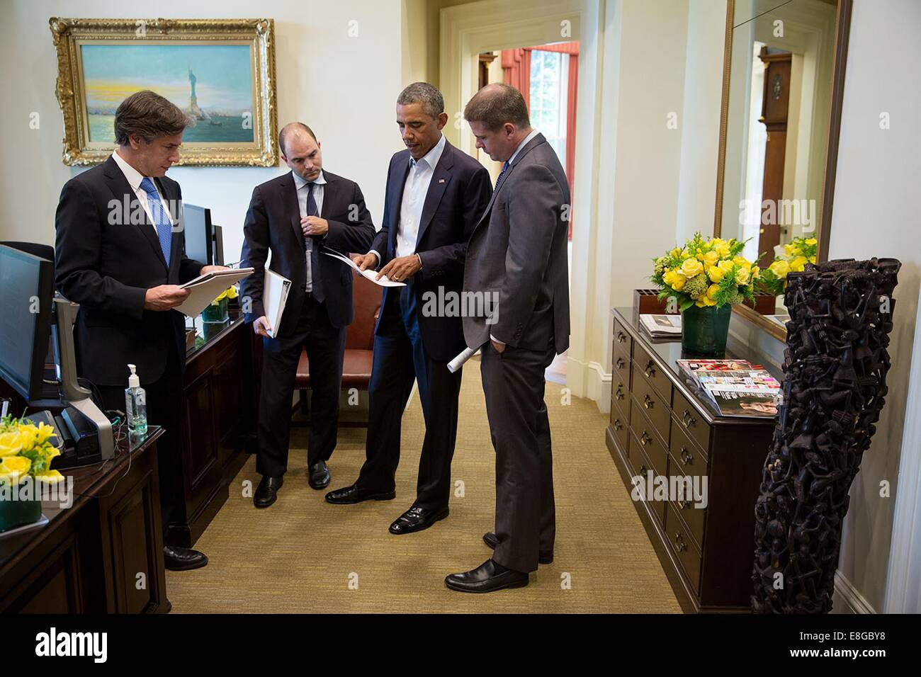 US President Barack Obama talks with, from left, Tony Blinken, Deputy National Security Advisor, Ben Rhodes, Deputy National Security Advisor for Strategic Communications, and Senior Advisor Dan Pfeiffer in the Outer Oval Office before making a statement in the Briefing Room of the White House August 18, 2014 in Washington, DC. Stock Photo