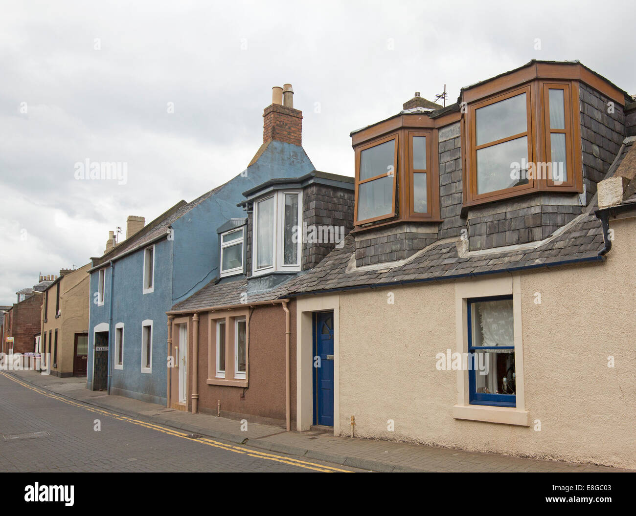 Row of bland terrace houses, some with dormer windows, crammed together along narrow street in coastal town of Arbroath Scotland Stock Photo
