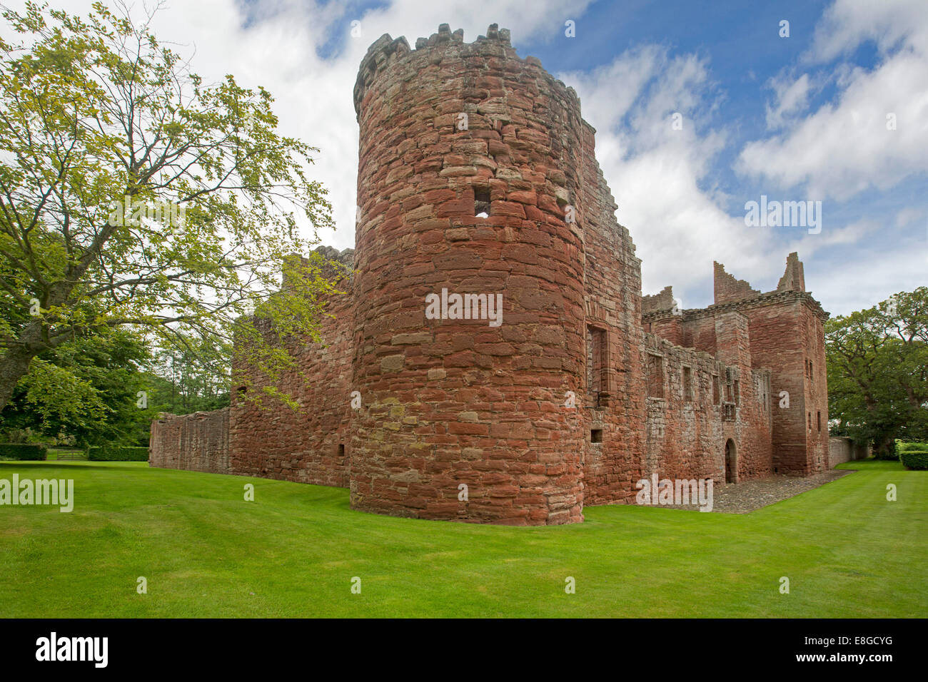 Extensive ruins of historic 16th century Edzell castle with cylindrical red stone towers & high walls under blue sky in Scotland Stock Photo