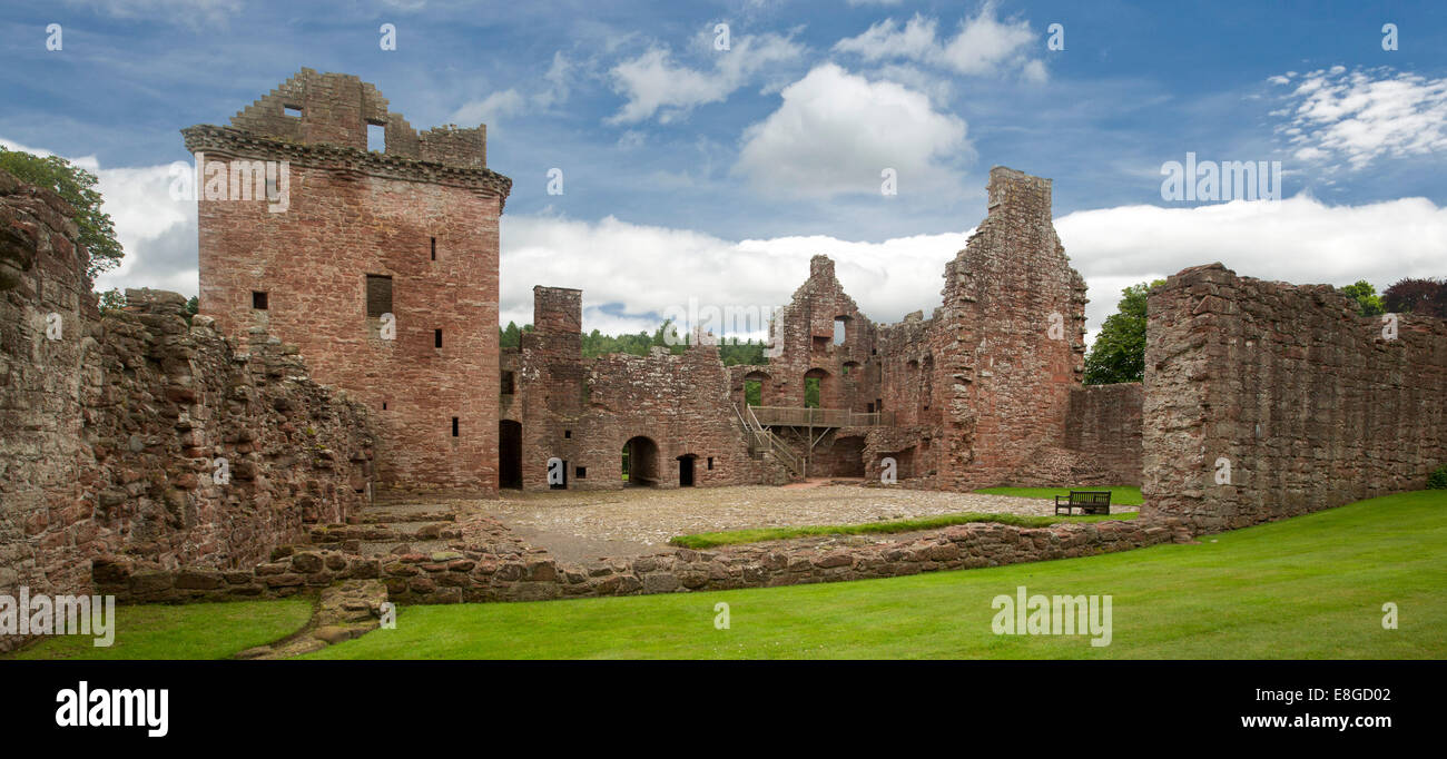 Extensive ruins of historic 16th century Edzell castle with red stone towers and high walls spearing into blue sky in Scotland Stock Photo