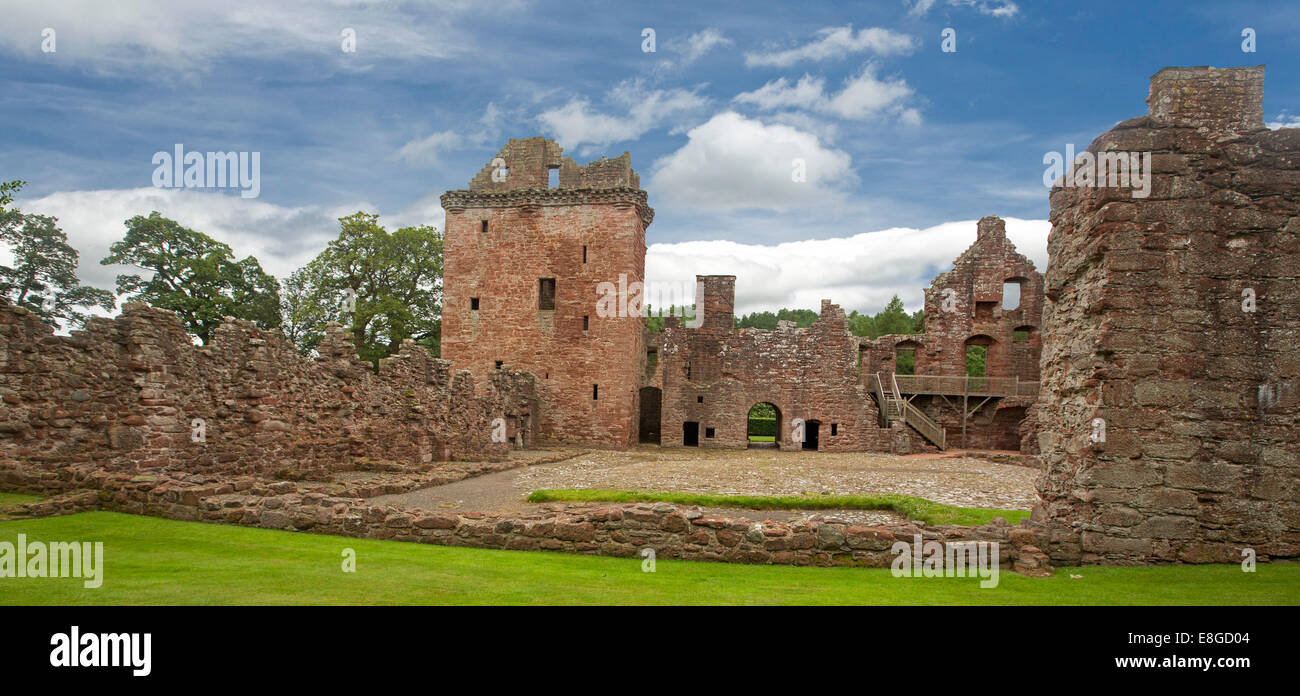 Picturesque ruins of historic 16th century Edzell castle with red stone towers and high walls under blue sky in Scotland Stock Photo