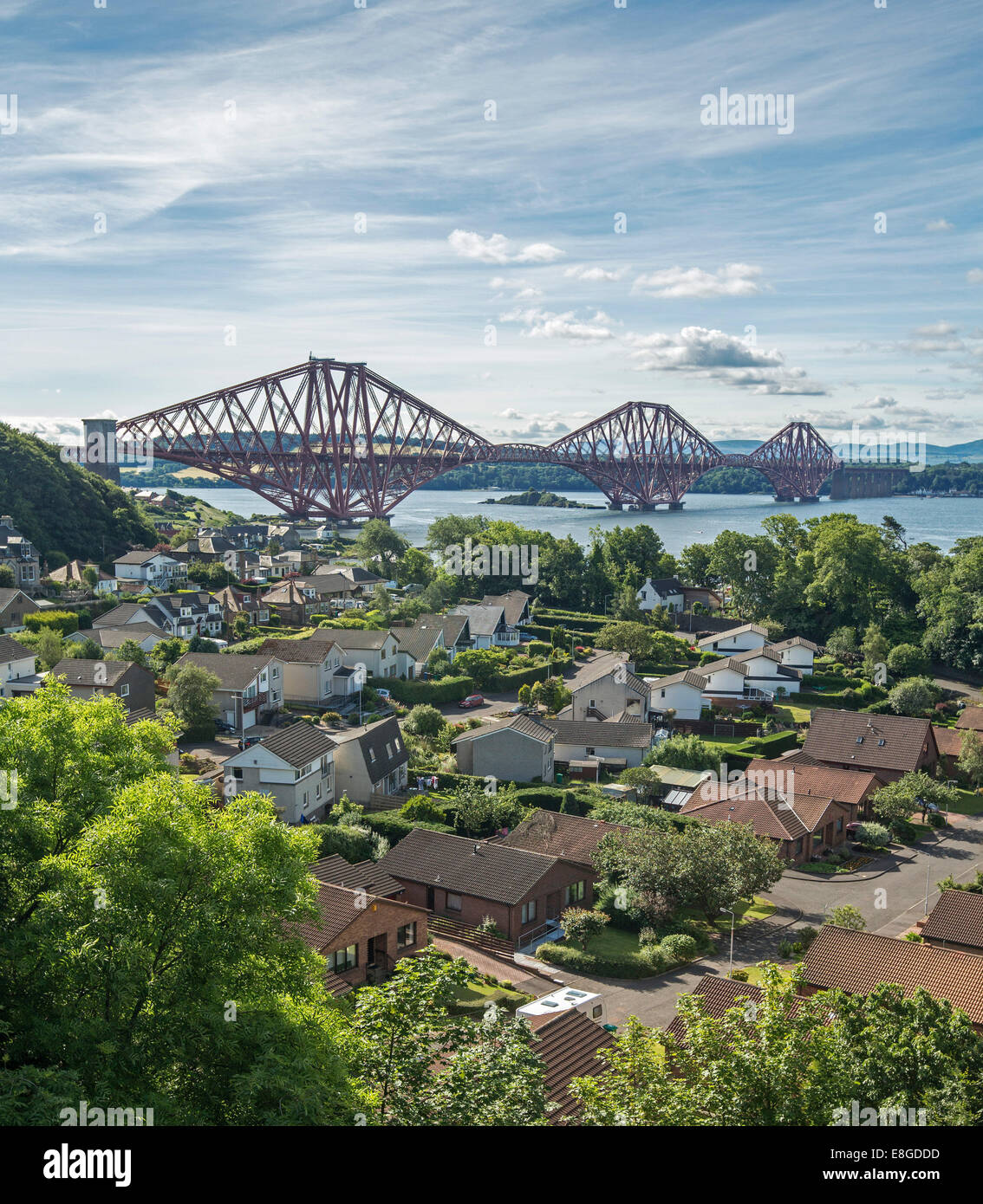 Iconic 19th century cantilever bridge over Firth of Forth with houses of riverbank town of Queenstown in foreground Scotland Stock Photo