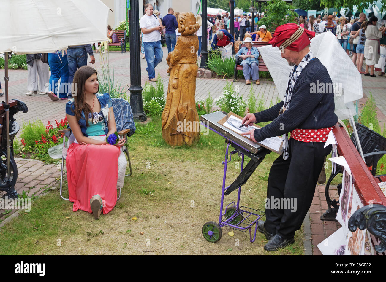 The artist draws a portrait. The fair of folk crafts and arts