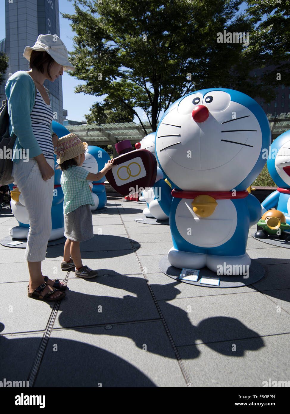 Japanese child meets a statue of Doraemon in Roppongi, Tokyo, Japan Stock Photo