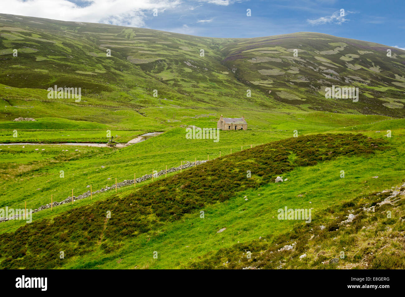Spectacular landscape in Scottish highlands with deserted cottage in valley surrounded by mountains in Cairngorms National Park Stock Photo