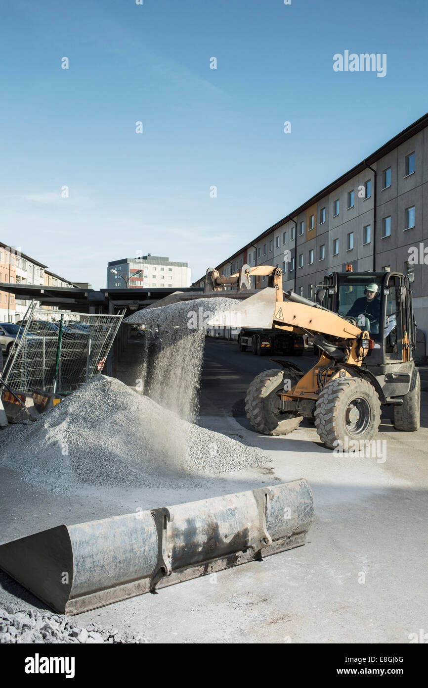 Construction worker using excavator at site Stock Photo - Alamy