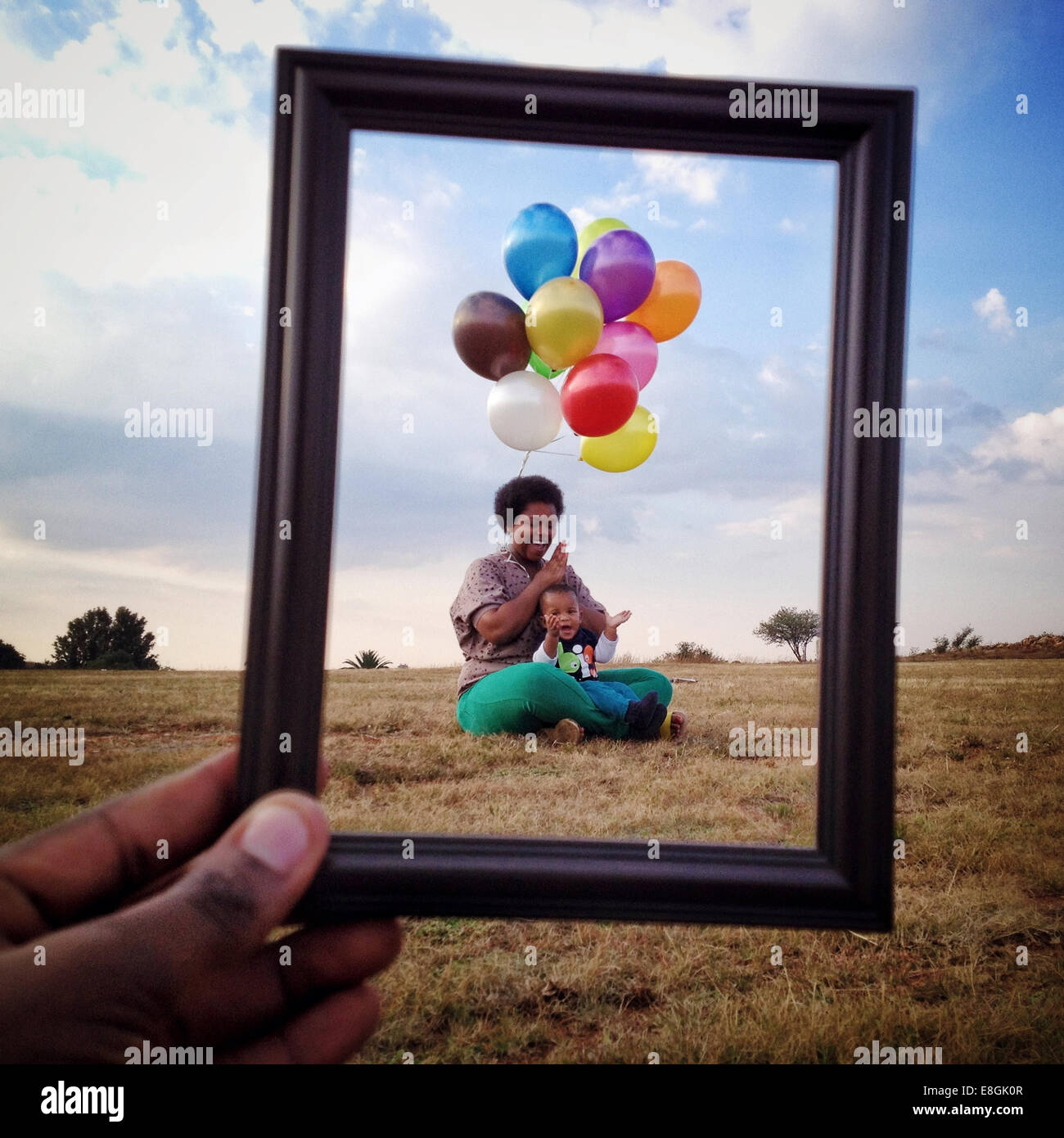 Man holding a Picture frame in front of a Mother and son in a meadow, Roodeport, Johannesburg, Gauteng, South Africa Stock Photo