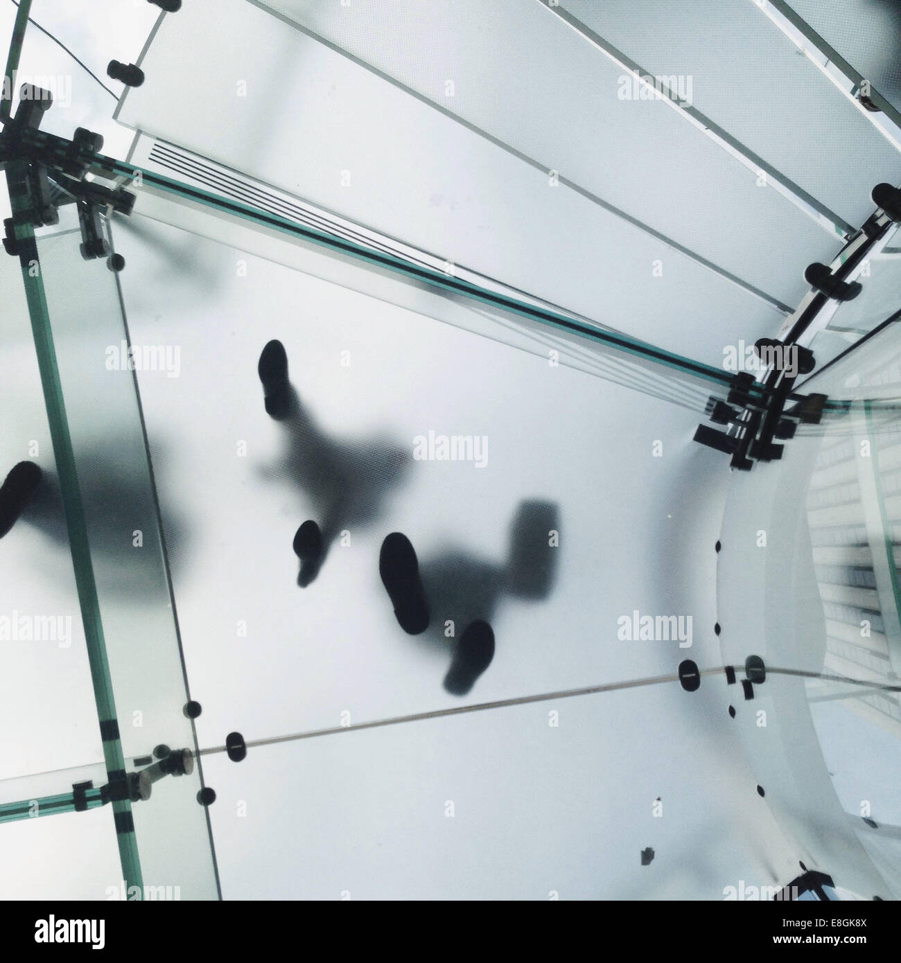 Low angle view of people walking on glass floor Stock Photo