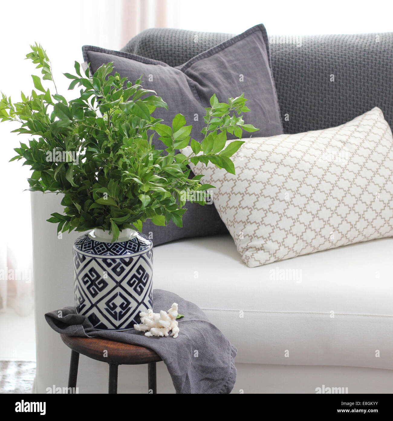 Living room couch with side table and plant Stock Photo