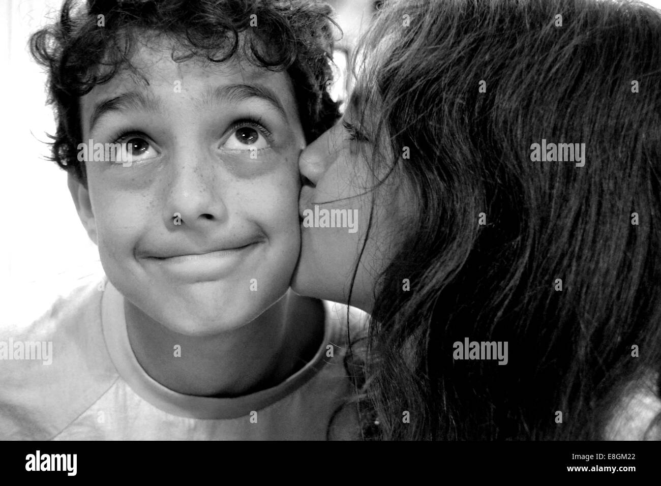 Girl kissing boy on the cheek Stock Photo