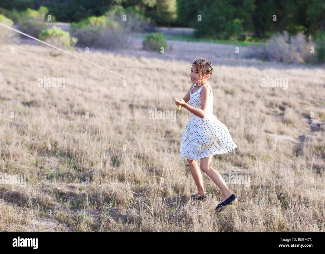 Girl flying a kite in the park Stock Photo