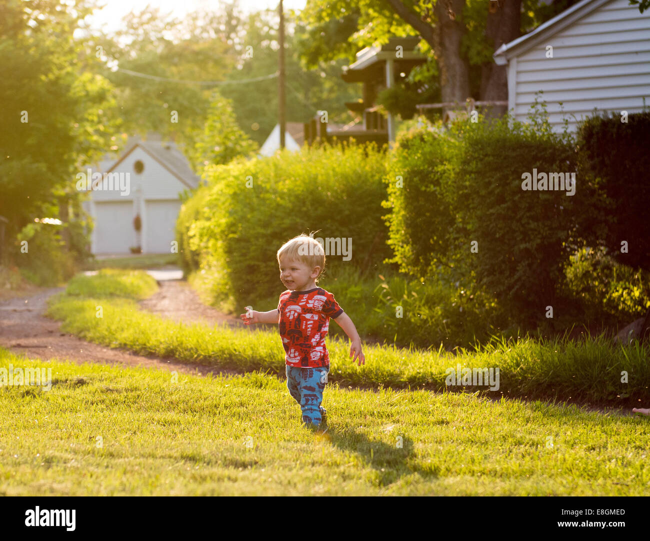 Boy playing in backyard Stock Photo
