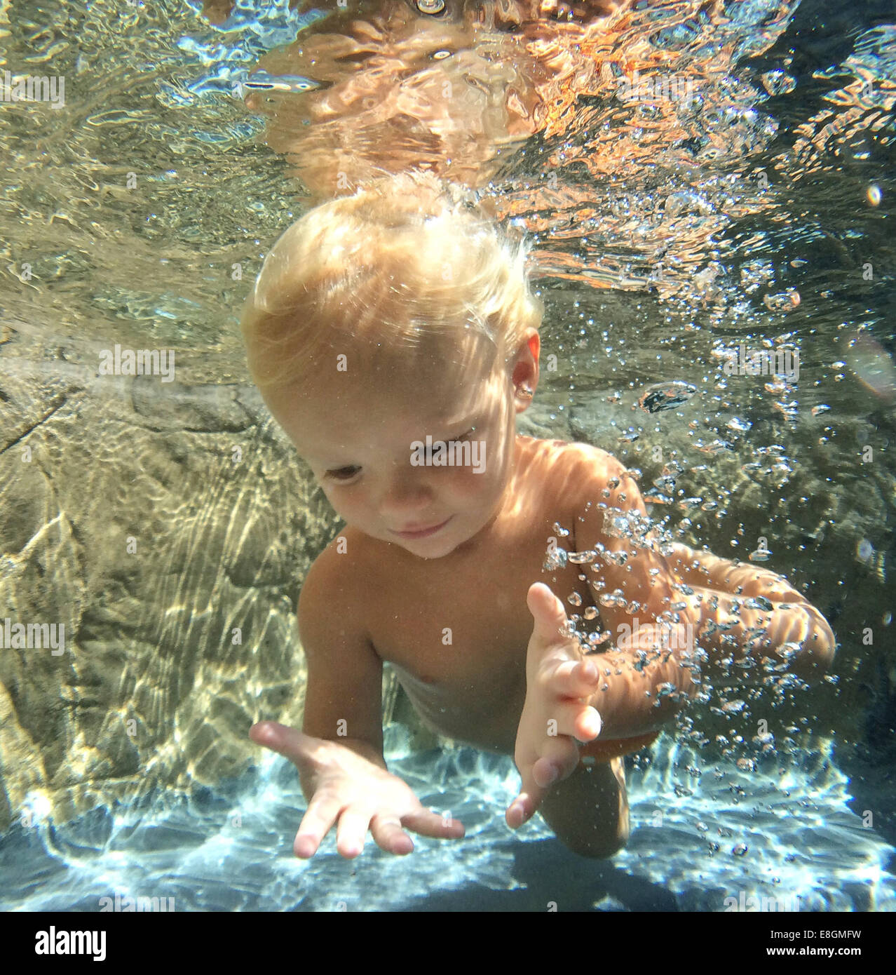 Boy swimming underwater in a swimming pool Stock Photo