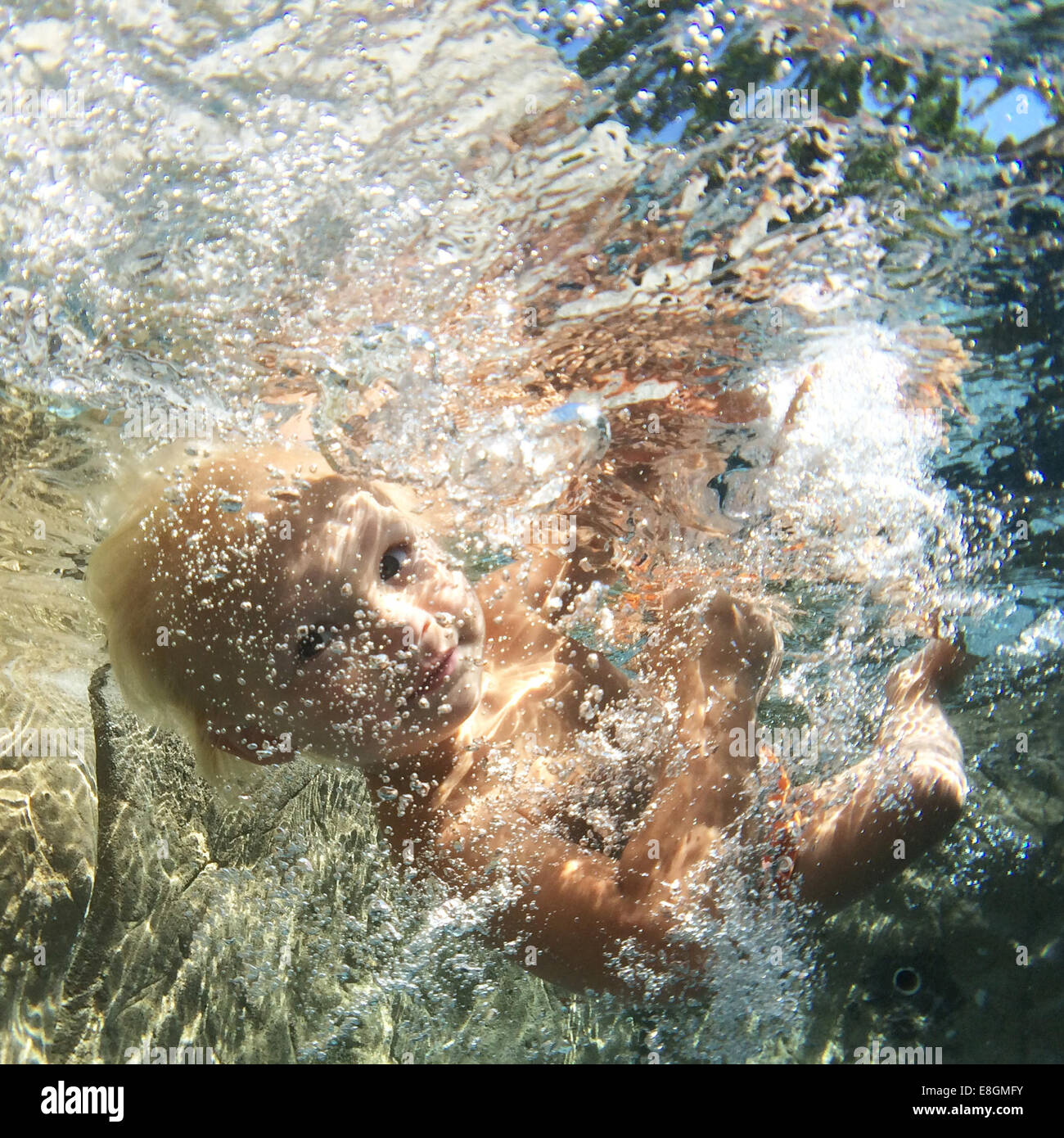 Boy swimming underwater in swimming pool Stock Photo