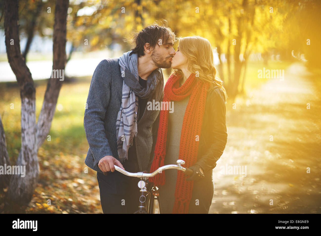 Young couple kissing in autumn park Stock Photo - Alamy