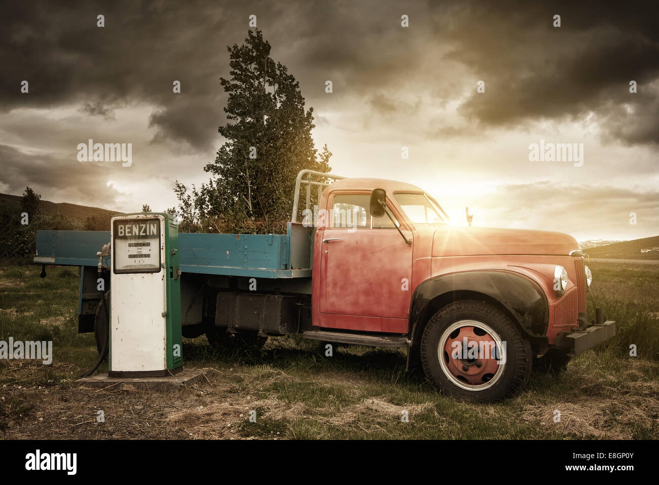 Classic truck with a vintage gas pump by sunset Stock Photo