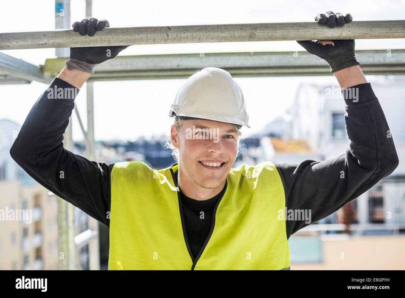 Happy construction worker looking away while standing at site Stock ...