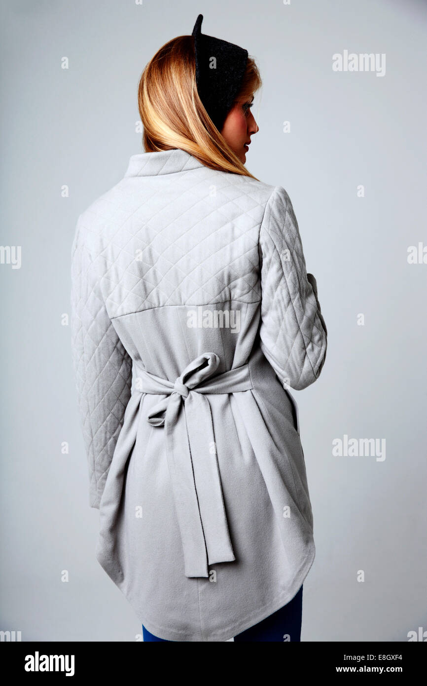 Back view portrait of a young woman on gray background Stock Photo - Alamy