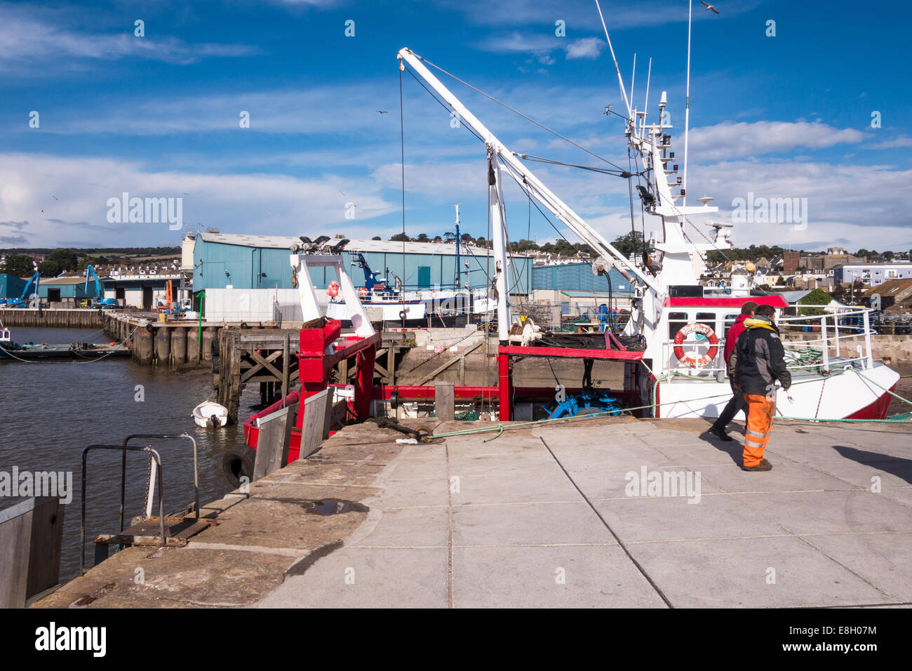The fish quay harbour port at Teignmouth in Devon with two boatmen