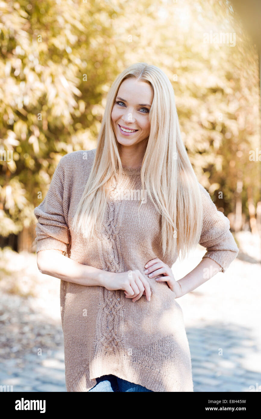 Portrait of smiling young woman wearing knit pullover Stock Photo - Alamy
