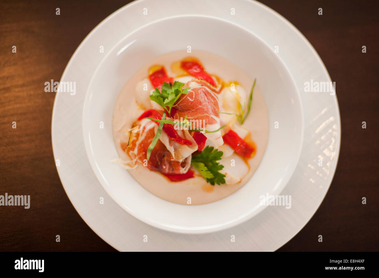Serrano ham, Parma ham, Red pepper, Artichoke mousse on plate Stock Photo