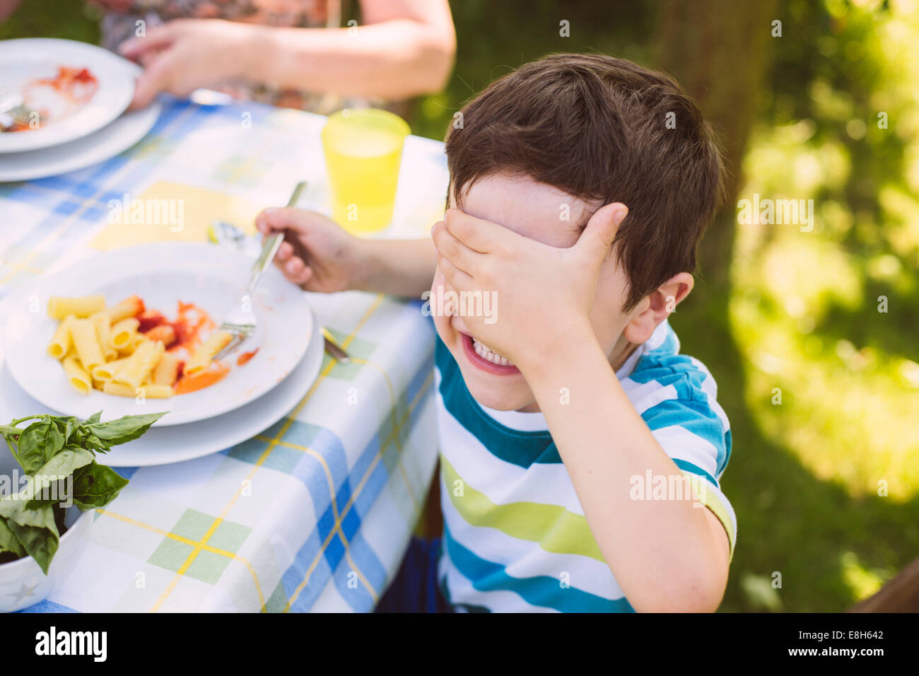 Boy covering his eyes on a garden party Stock Photo - Alamy