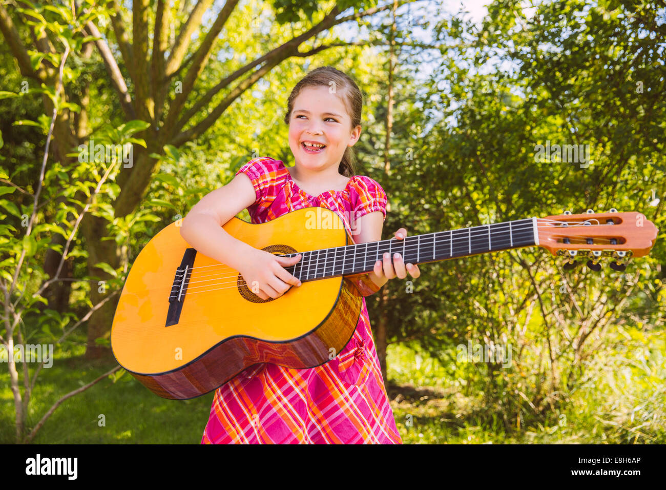 Girl playing guitar in garden Stock Photo Alamy