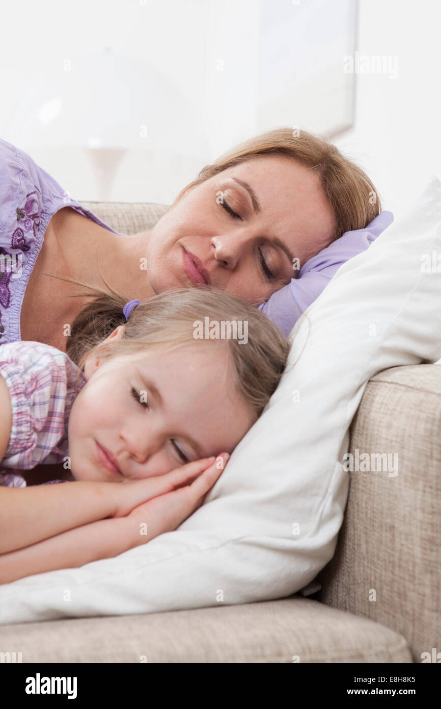 Germany, Munich, Mother and daughter (4-5) sleeping on sofa Stock Photo