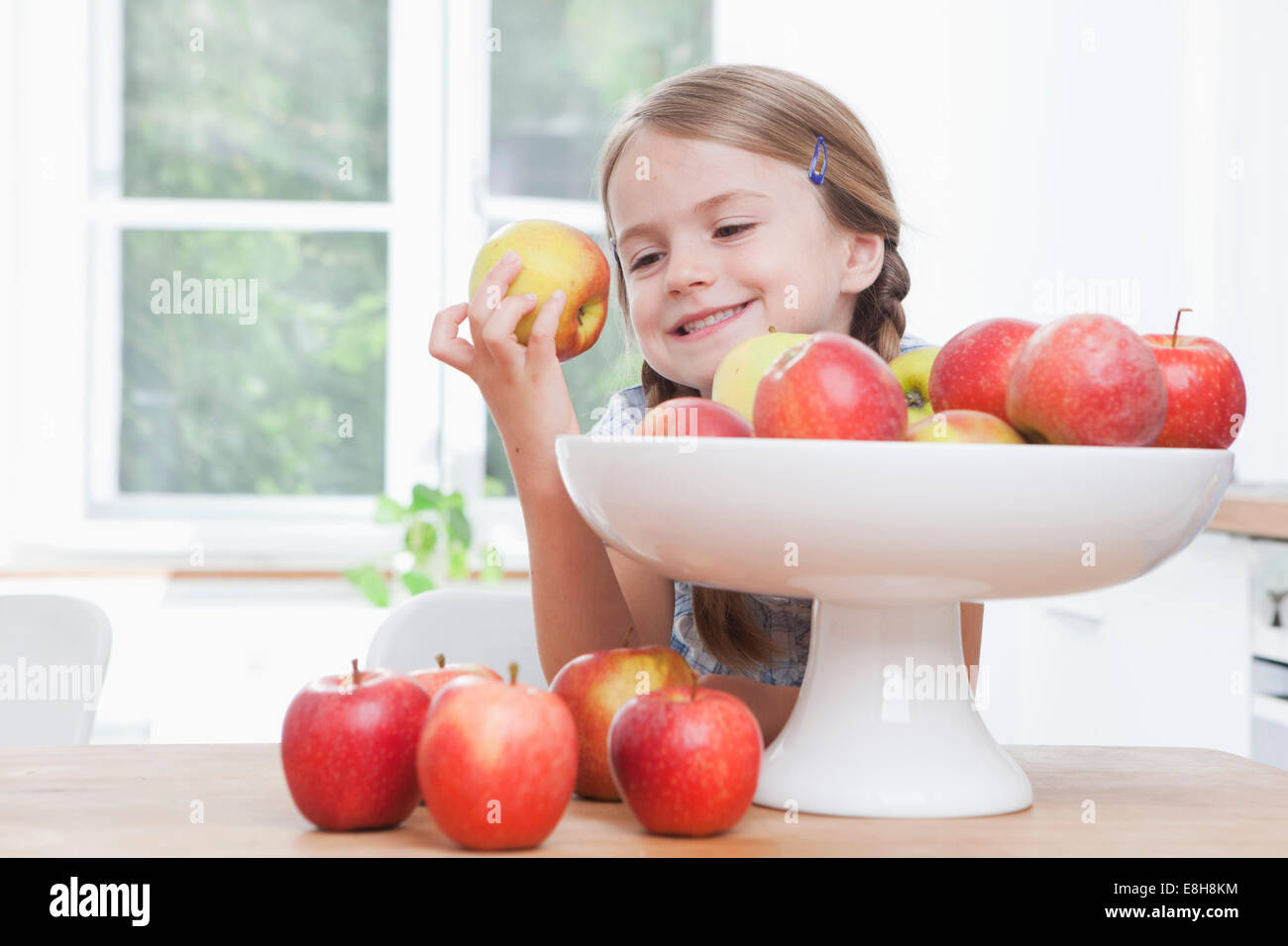 Germany, Munich, Girl (6-7) taking apple from bowl Stock Photo
