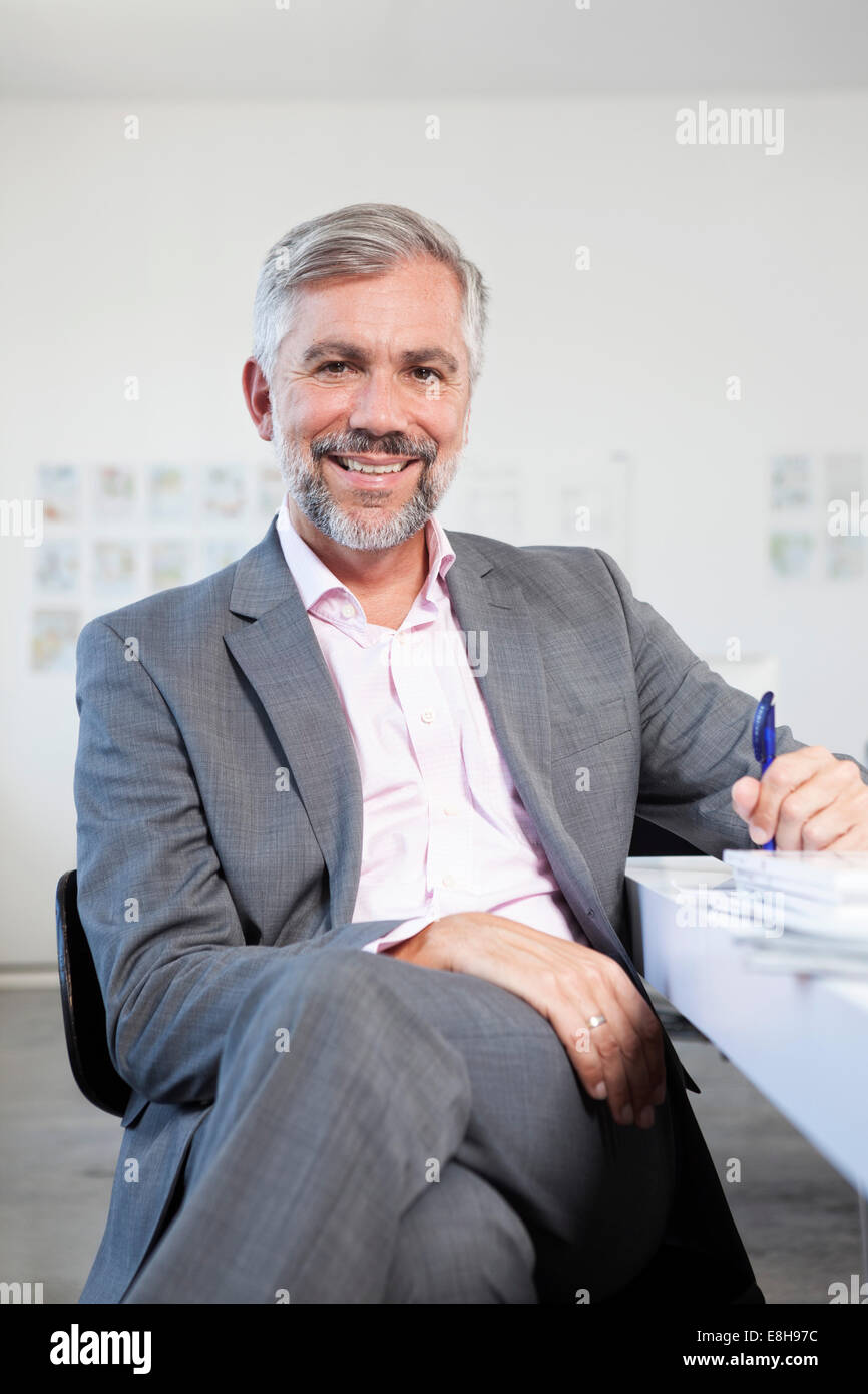 Portrait of smiling man at his desk in an office Stock Photo - Alamy