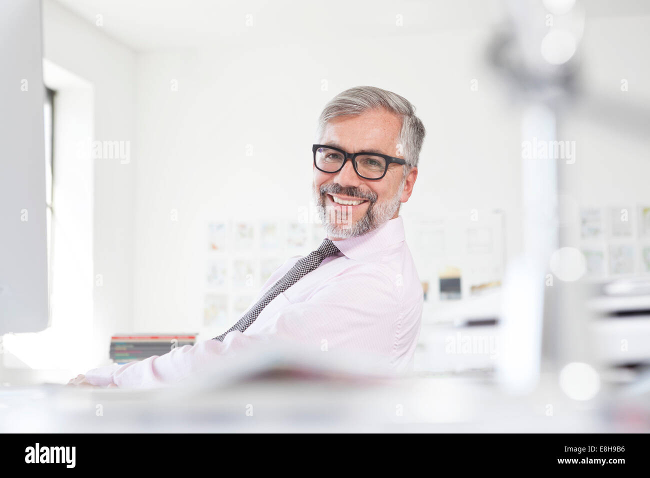 Portrait of smiling man at his desk in an office Stock Photo - Alamy