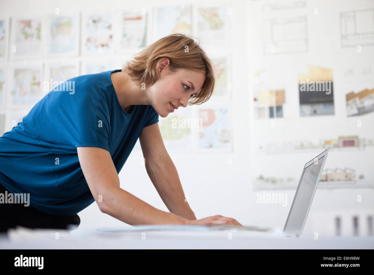 Portrait of young woman using laptop in a creative office Stock Photo