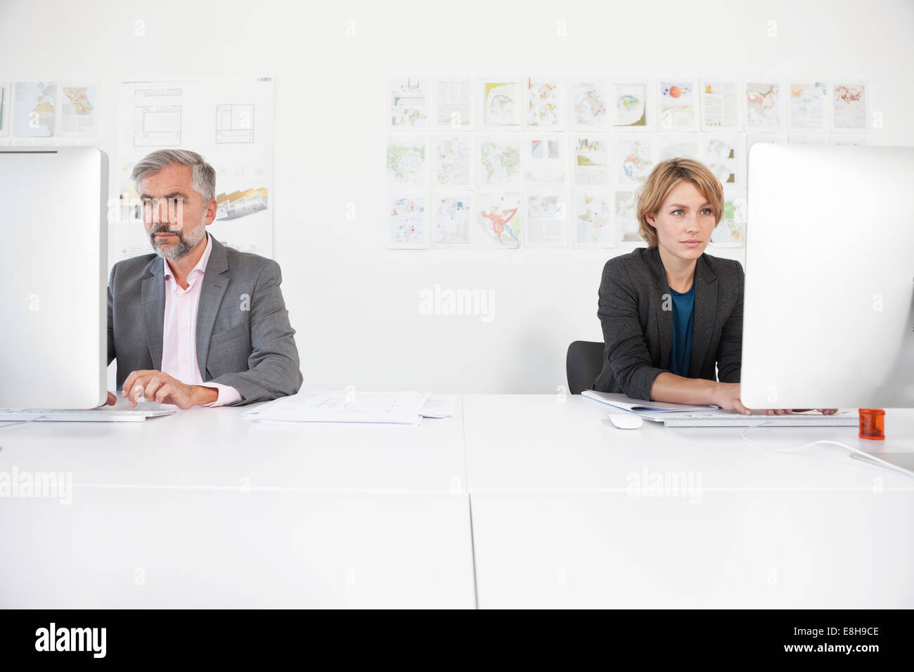 Two colleagues working side by side in an office Stock Photo