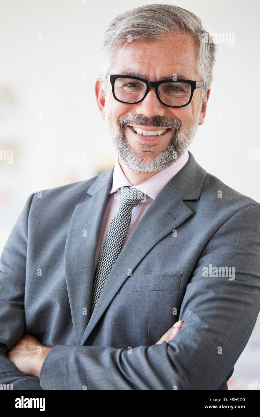 Portrait of smiling businessman with crossed arms Stock Photo - Alamy