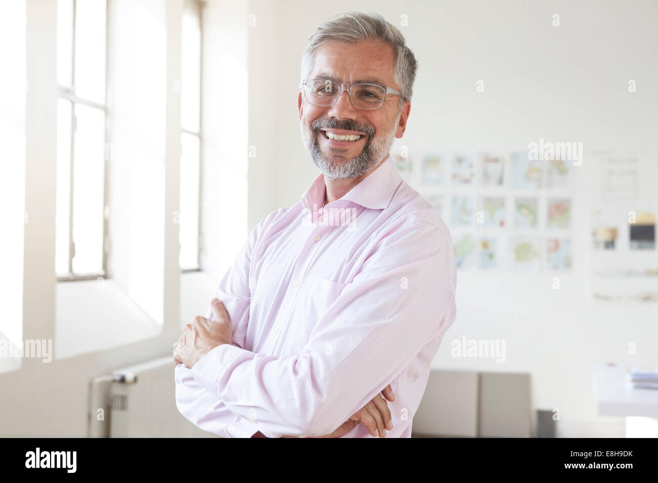 Portrait of smiling businessman with crossed arms in an office Stock ...