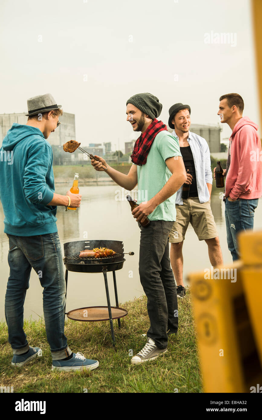 Group of friends drinking beer and having a barbecue Stock Photo - Alamy