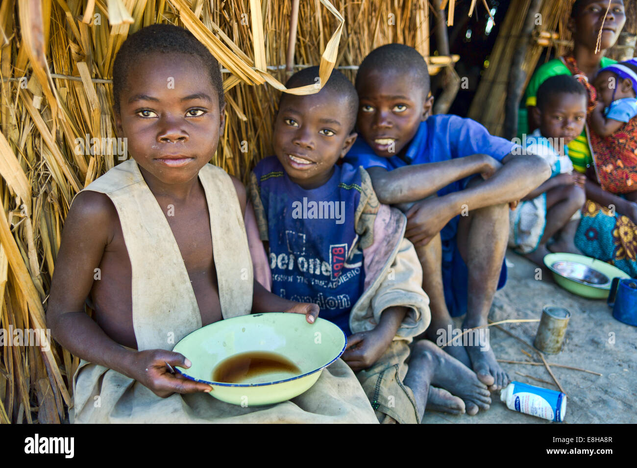 Children in a fishing village in Zambia enjoy a broth for breakfast. Stock Photo