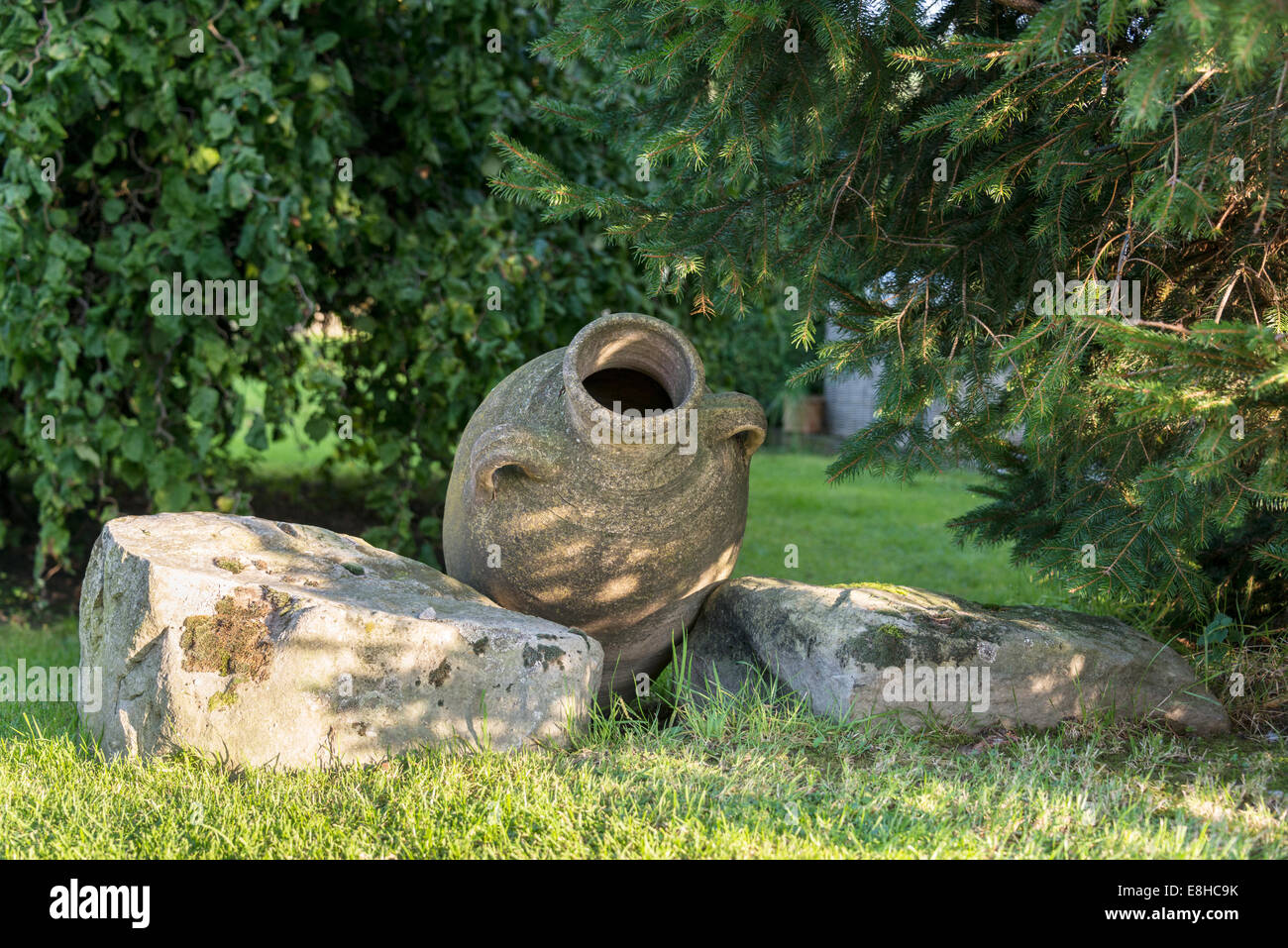 old concrete vase and rocks as garden decoration Stock Photo