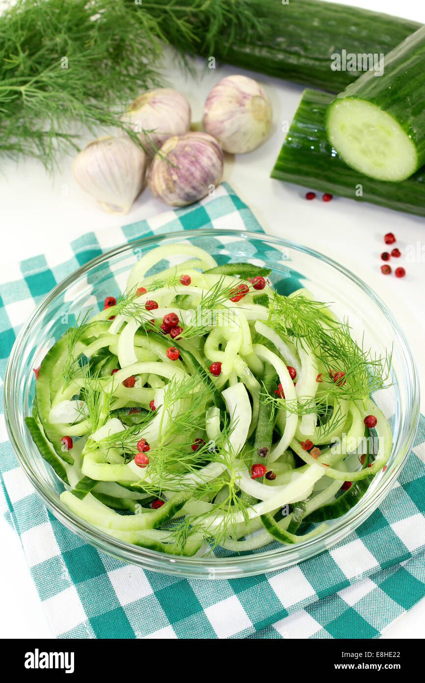 a bowl of cucumber salad with dill and red pepper berries Stock Photo