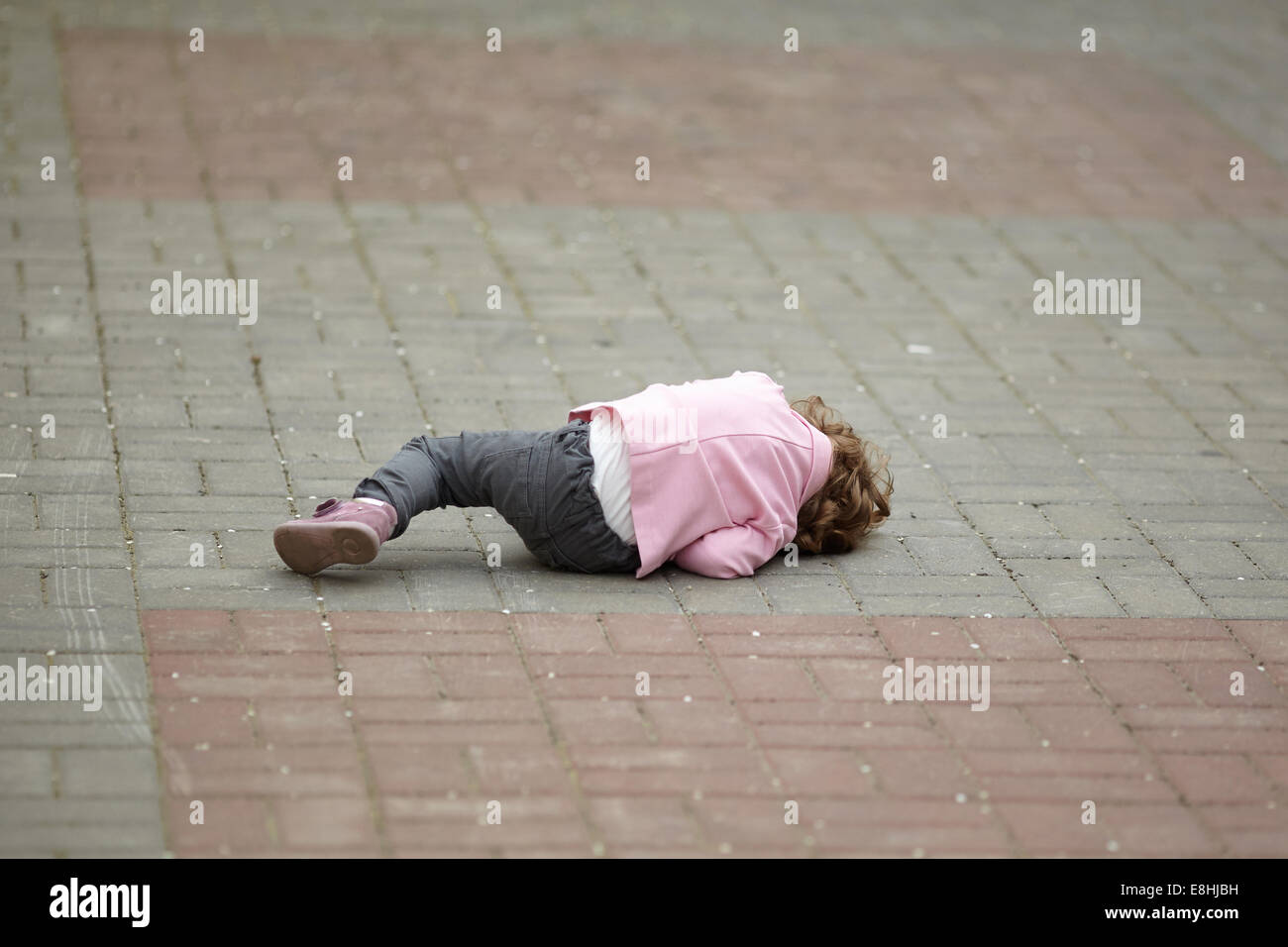 alone crying girl lying on asphalt Stock Photo